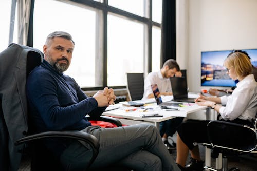 Free A Man in Sitting with His Colleagues Stock Photo