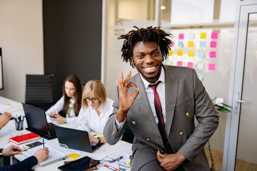 Smiling businessman signaling OK, working with diverse team in modern office.