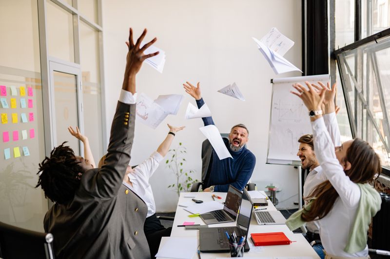 Office team throwing papers in the air