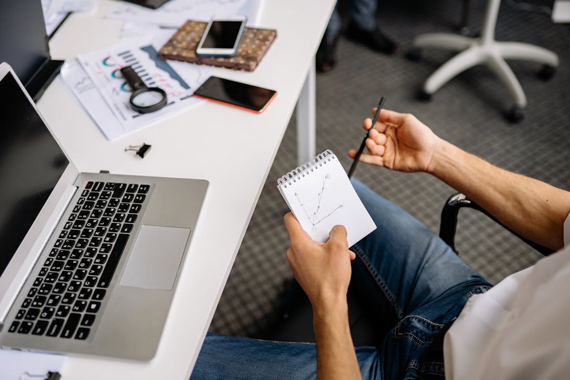 Person Holding Notepad with Chart · Free Stock Photo