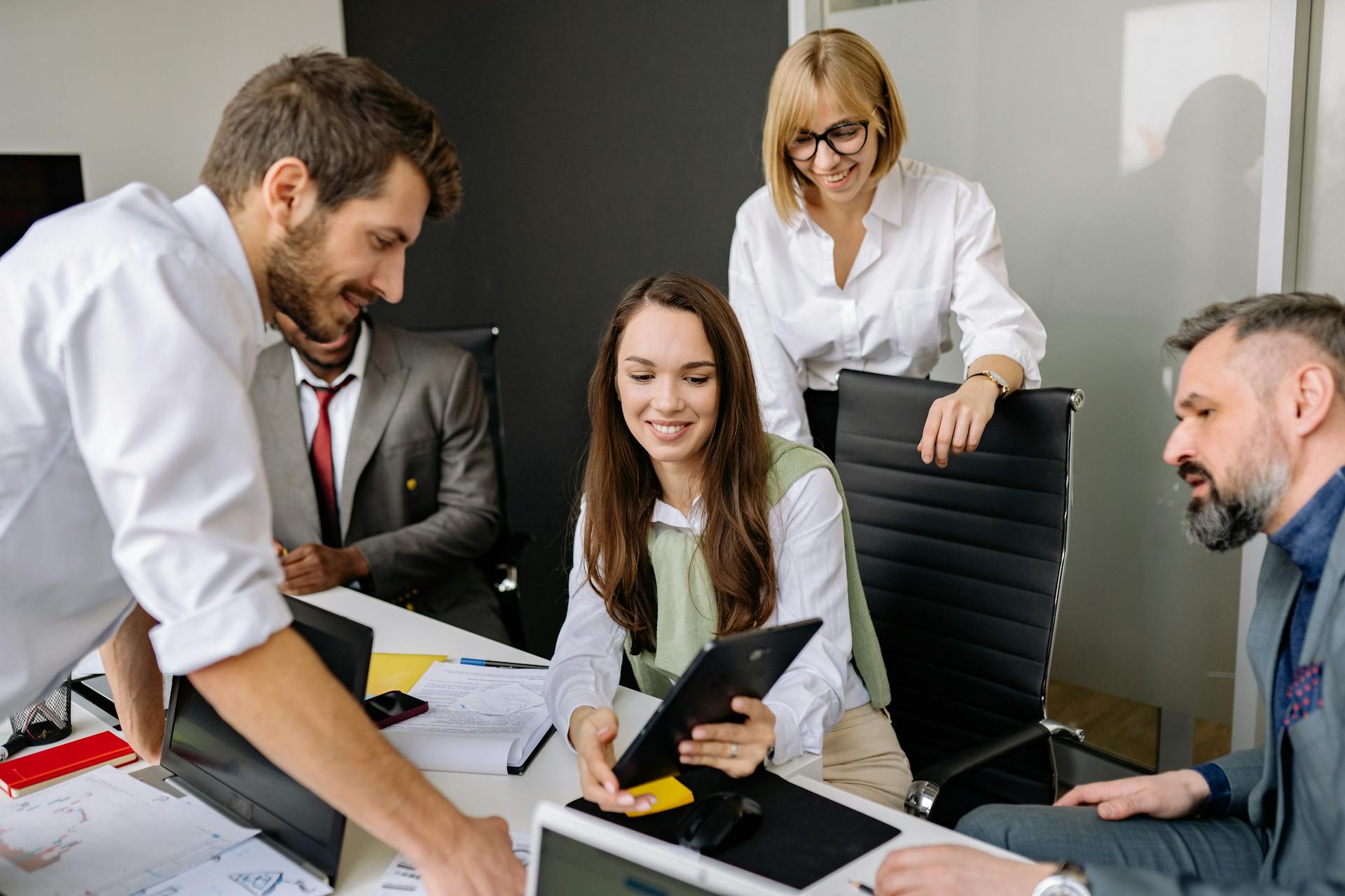 Diverse team collaborating with digital tablet during an office meeting. Perfect for business and teamwork themes.