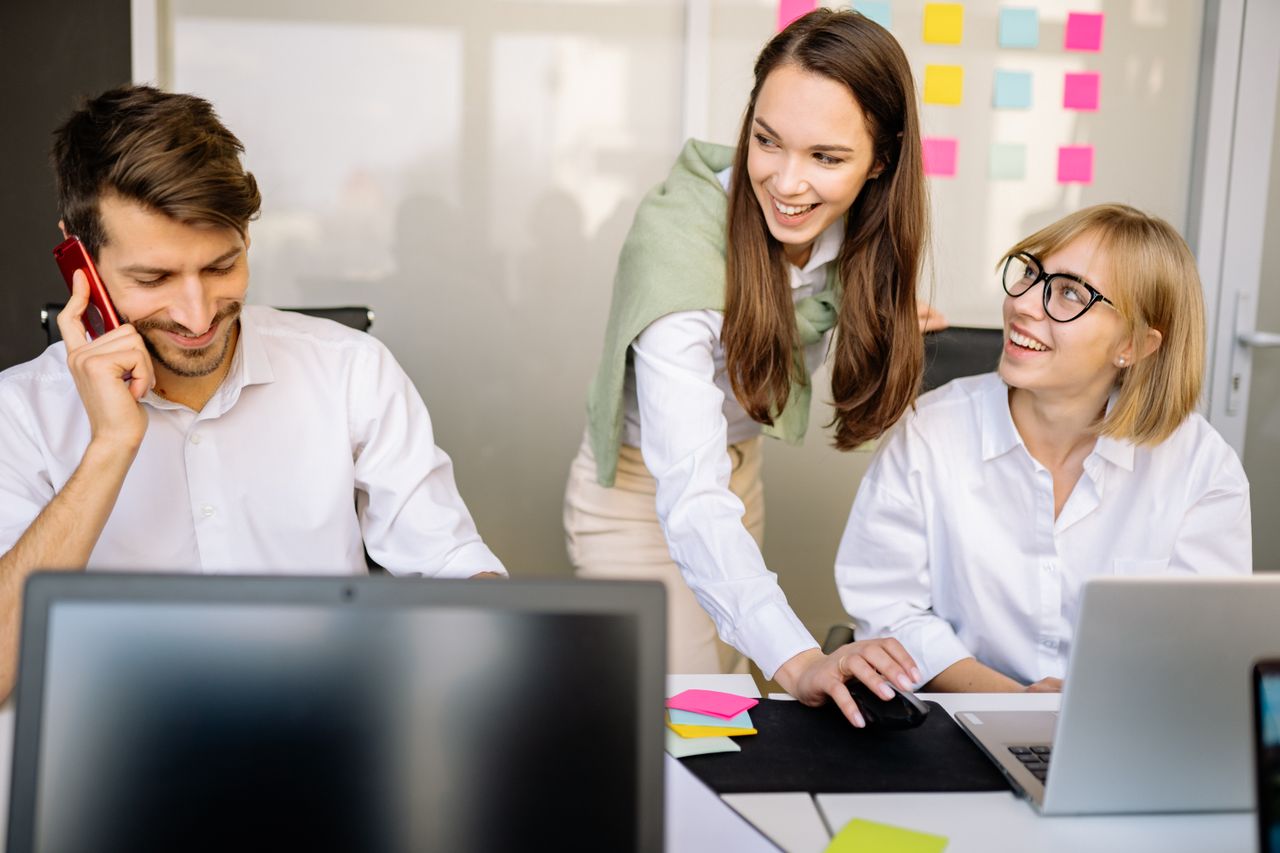 Equipo atendiendo a clientes con una sonrisa en la oficina