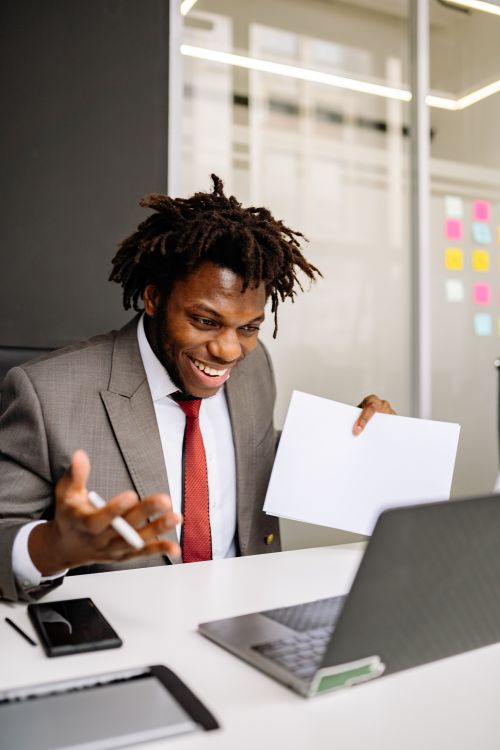 Free Excited young businessman celebrates success while working on a laptop in a modern office. Stock Photo