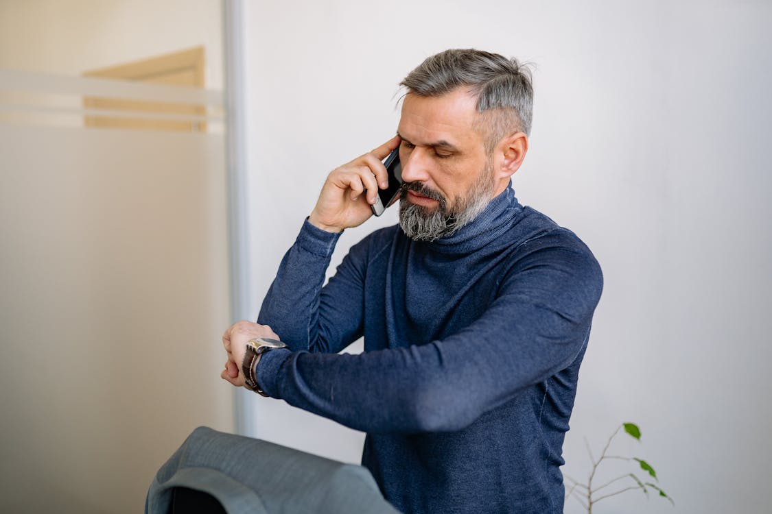 Man in Blue Sweater Sitting on Black Chair