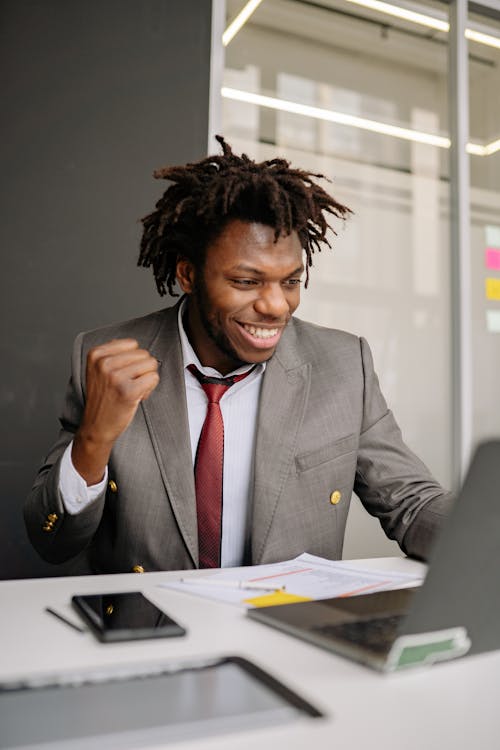 A Happy Man with Dreadlocks Wearing a Suit