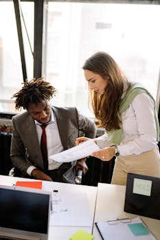 Two colleagues collaborating on a project in a bright, modern office space.