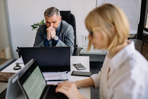 Free Two professionals engaged in intense office work with laptops, showcasing teamwork and focus. Stock Photo