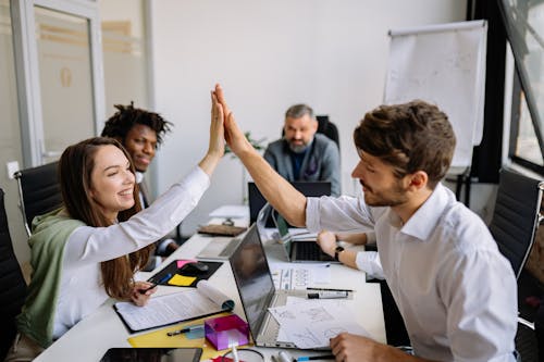 Free Man and Woman Doing High Five at the Meeting Stock Photo