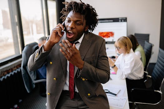 Energetic businessman in a suit having a phone call in a busy office environment.