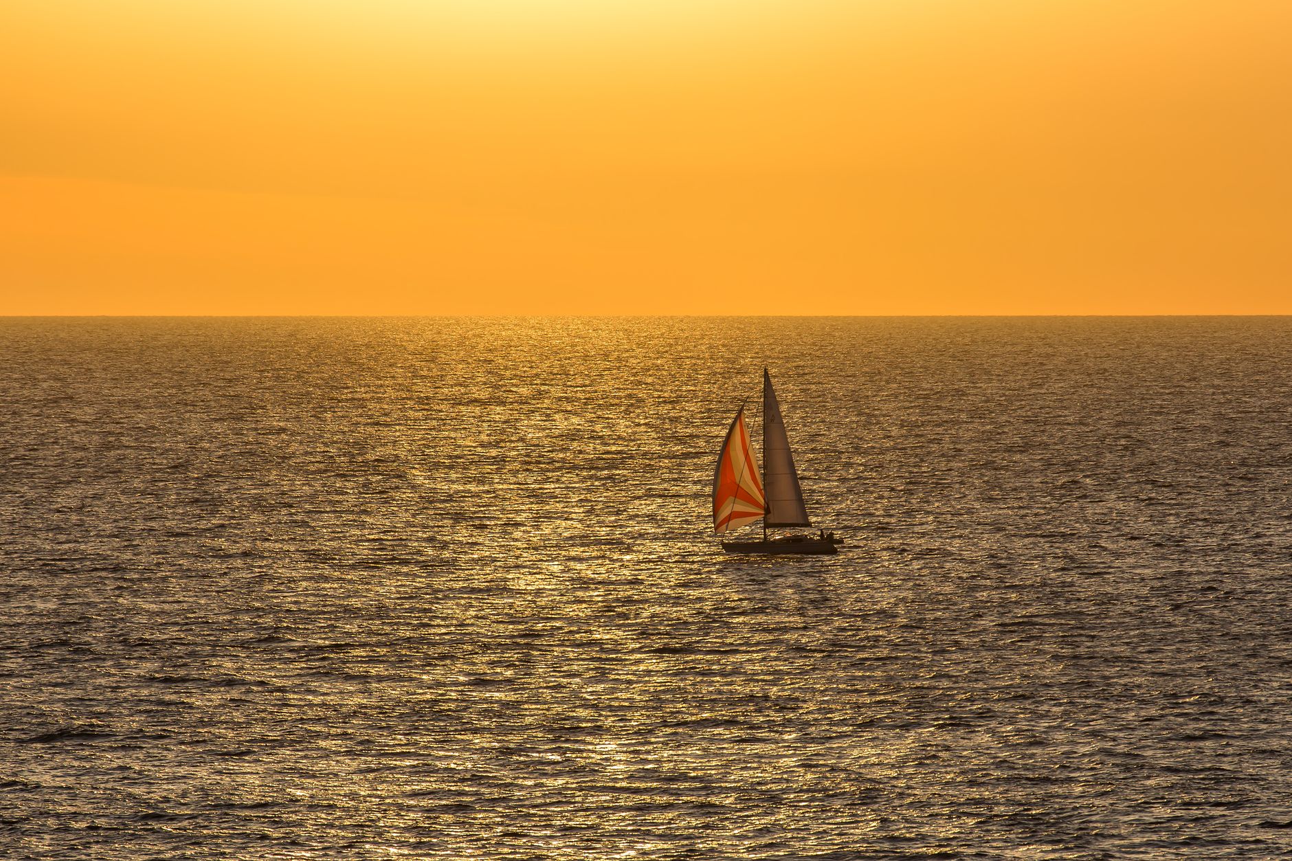sailboat at golden sunset on the ocean