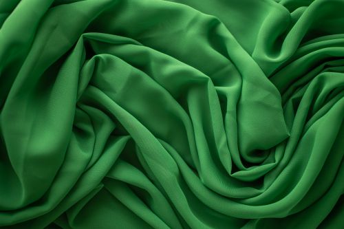 Free From above of textured background of creased green textile with uneven surface and wavy lines Stock Photo