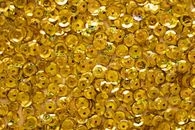 Top view of closeup of golden shiny round shaped rhinestones randomly placed on surface