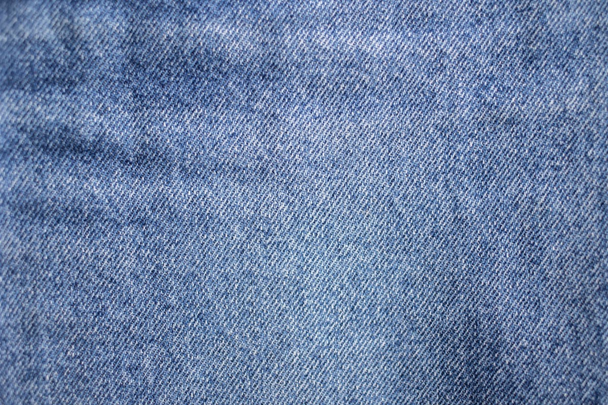 From above of textured background representing light blue denim textile with uneven rough texture