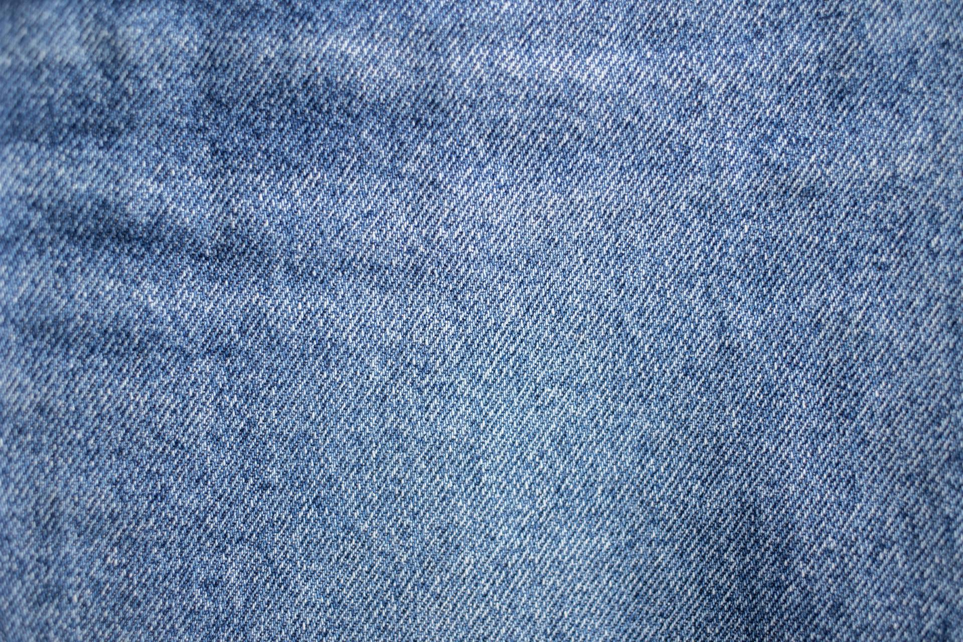 From above of textured background representing light blue denim textile with uneven rough texture