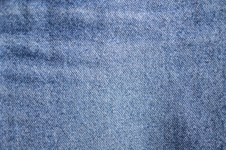 From above of textured background representing light blue denim textile with uneven rough texture