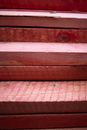 Part of withered red colored uneven wooden stairs with textured surface in daylight