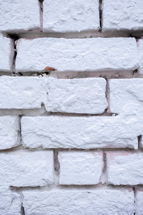 Free Background of textured shabby white wall made of rough bricks with uneven surface Stock Photo