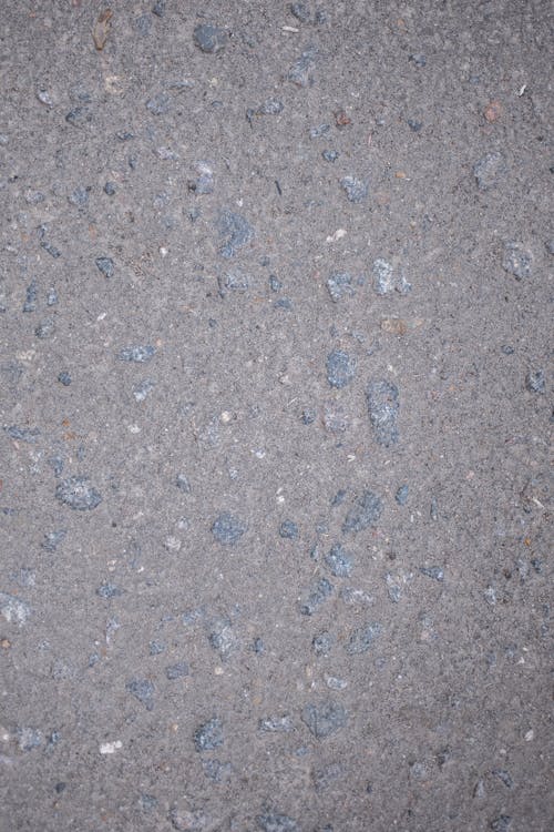 Abstract textured background of rough uneven surface of gray color with stone inclusions