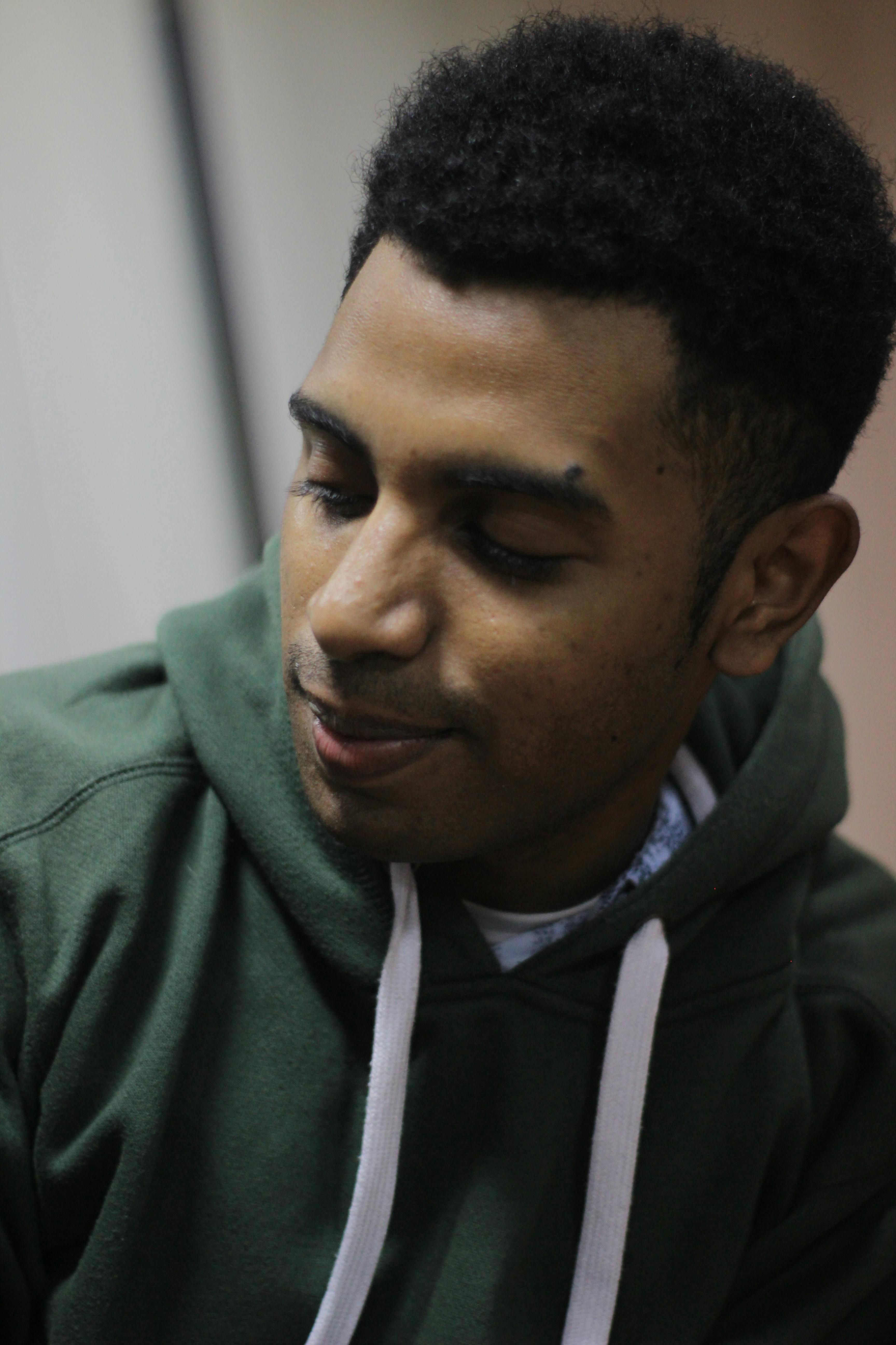 A person playing a video game on a modern setup with a large monitor and ambient lighting.