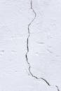 Textured background of rough uneven surface with cracks and scratches on white wall