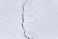 Surface of aged white wall with crack