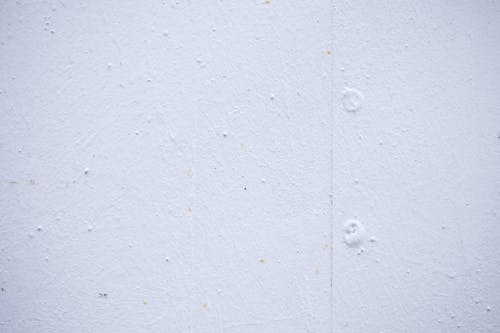 Textured backdrop of wall with spots and dots on shabby light blue surface