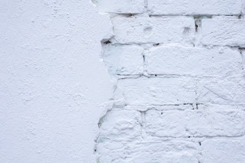 Free Rough white wall of bricks and plaster Stock Photo