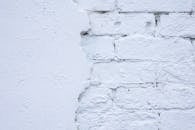 Rough white wall of bricks and plaster