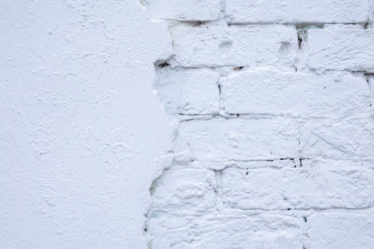 Rough White Wall Of Bricks And Plaster