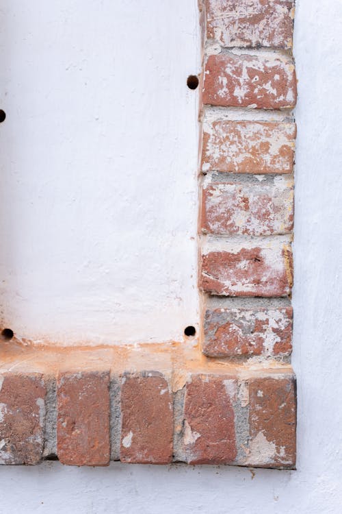 Old bricks forming rows in white wall