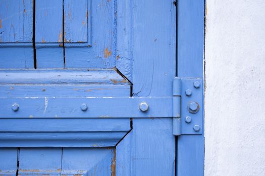 Shabby blue wooden door with metal hinge