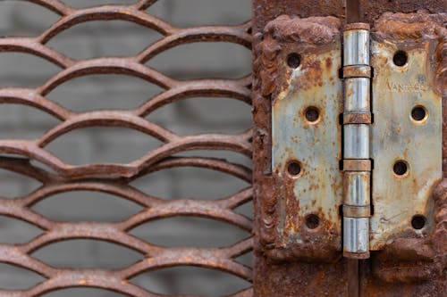 Old metal door hinge with weathered lattice