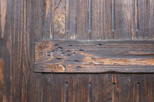 Free Textured background of weathered brown aged wooden wall with scratches and holes differently directed boards Stock Photo
