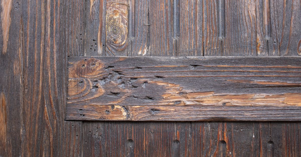 Textured background of weathered brown aged wooden wall with scratches and holes differently directed boards