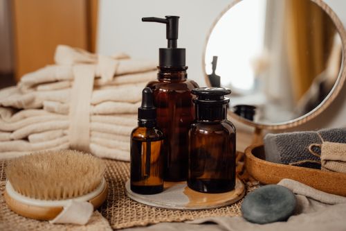 Free A sophisticated arrangement of toiletry bottles, towels, and decor in a bathroom setting, perfect for modern home aesthetics. Stock Photo