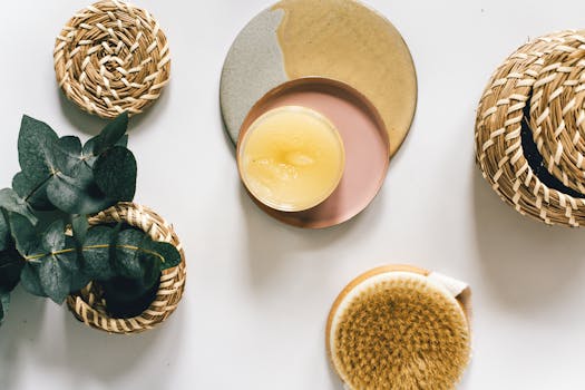 Flatlay of natural skincare products with eucalyptus leaves in a cozy setting.