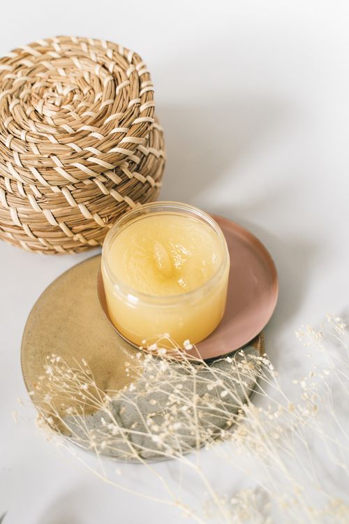 Free Close-up of a skincare cream jar with elegant plates and a woven basket in a minimalist setting. Stock Photo