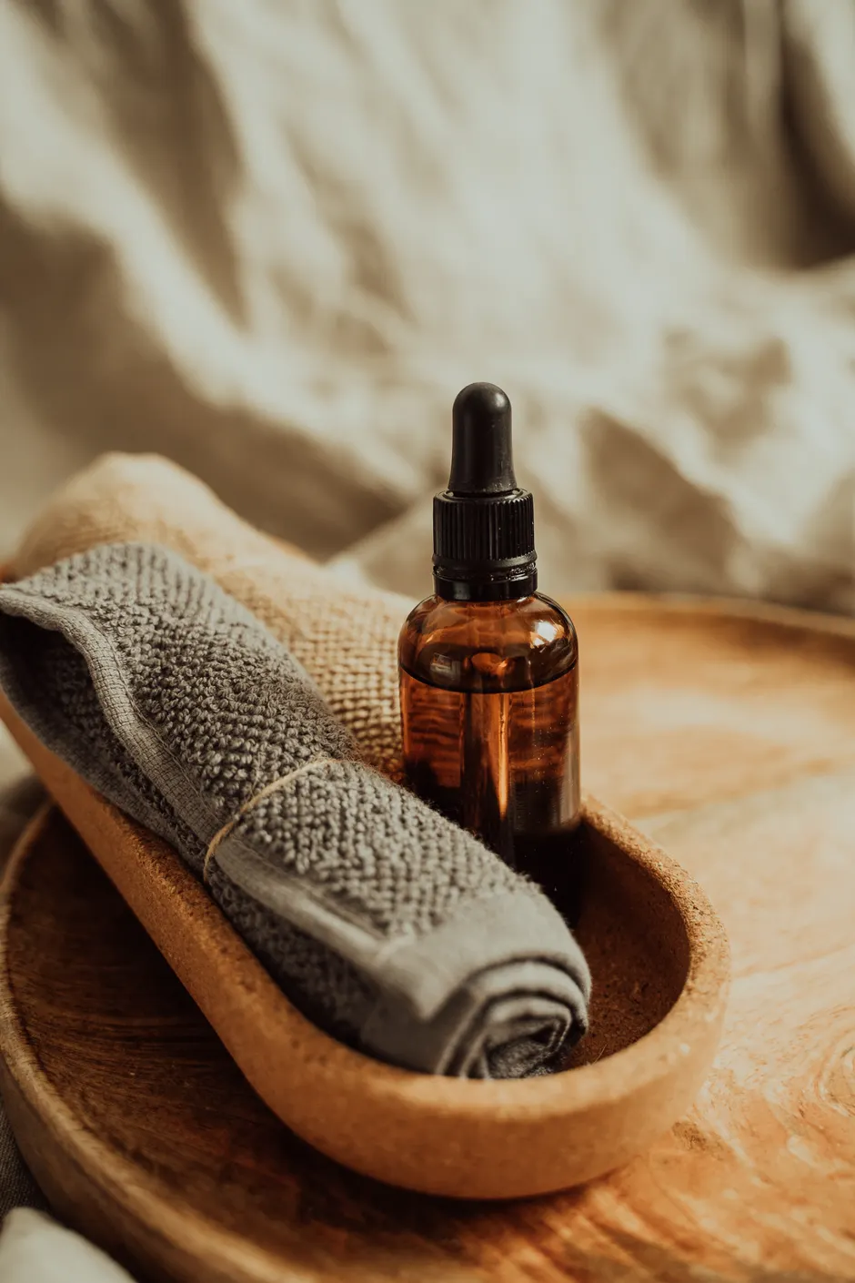 Flacon d’huile de massage ambré sur un plateau en bois