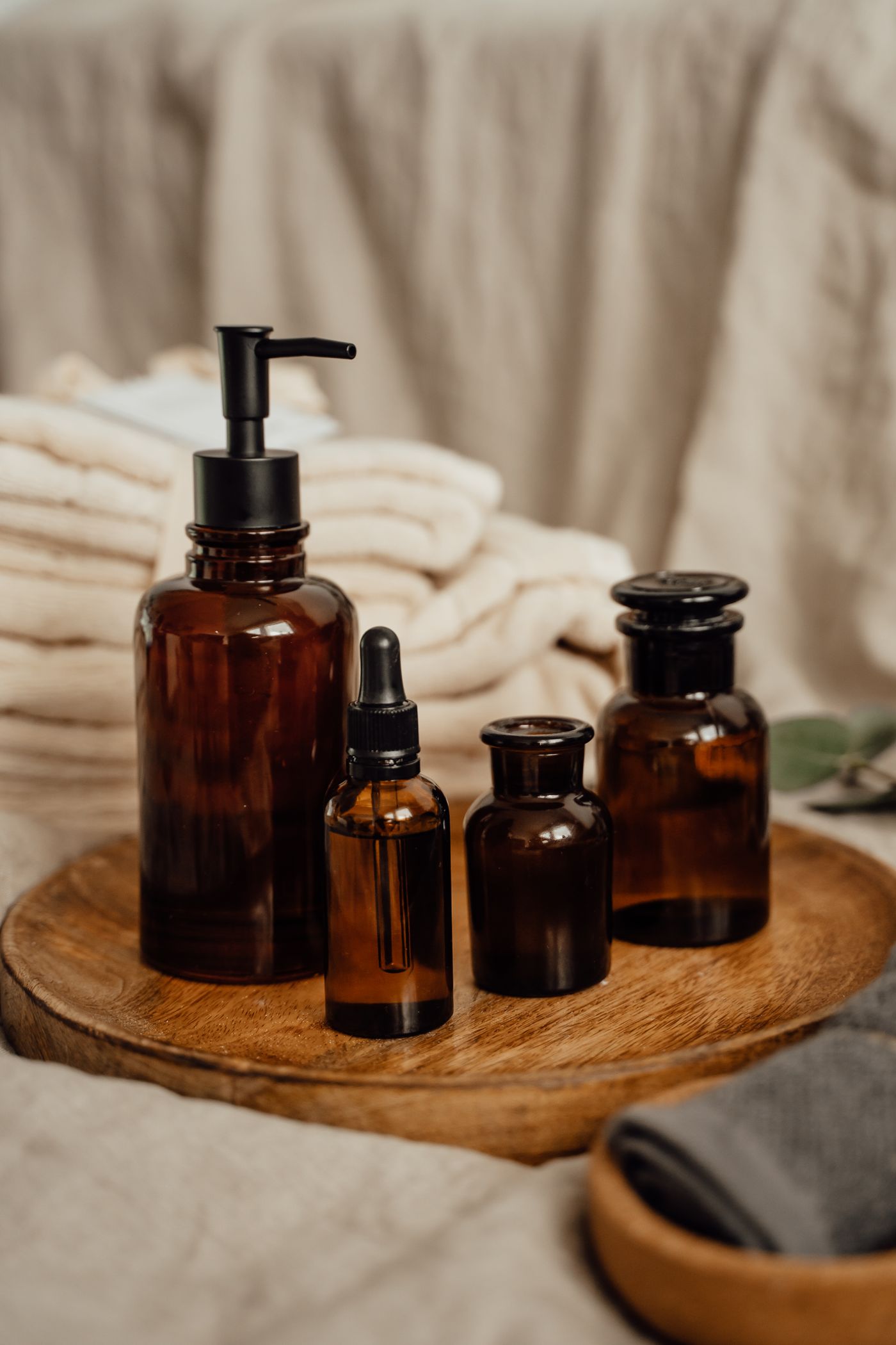 Amber glass bottles on a wooden tray