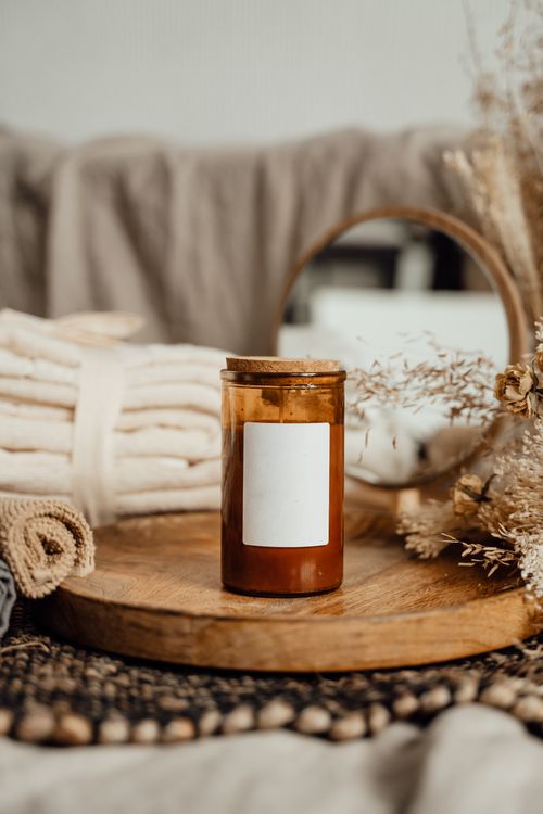 Free Warm toned decor featuring a candle and dried flowers on a wooden tray for a soothing ambiance. Stock Photo