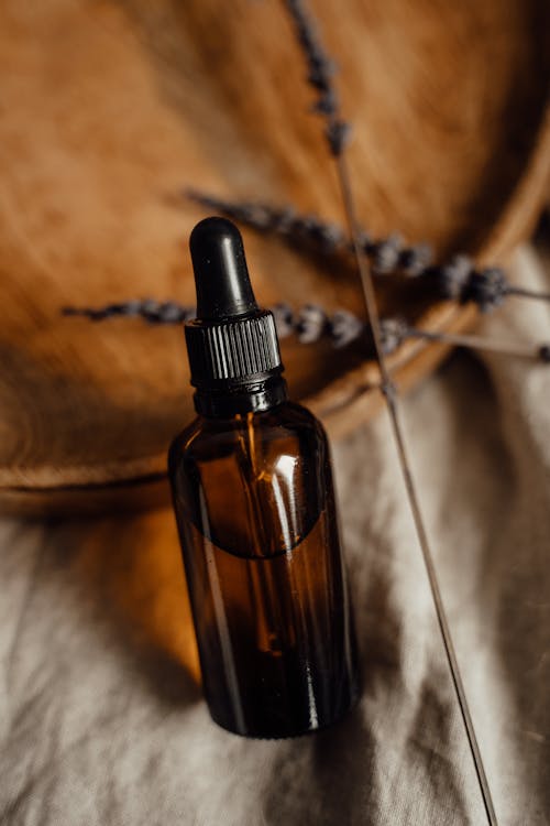 Dropper Glass Bottle on Linen Beside Lavender Stems