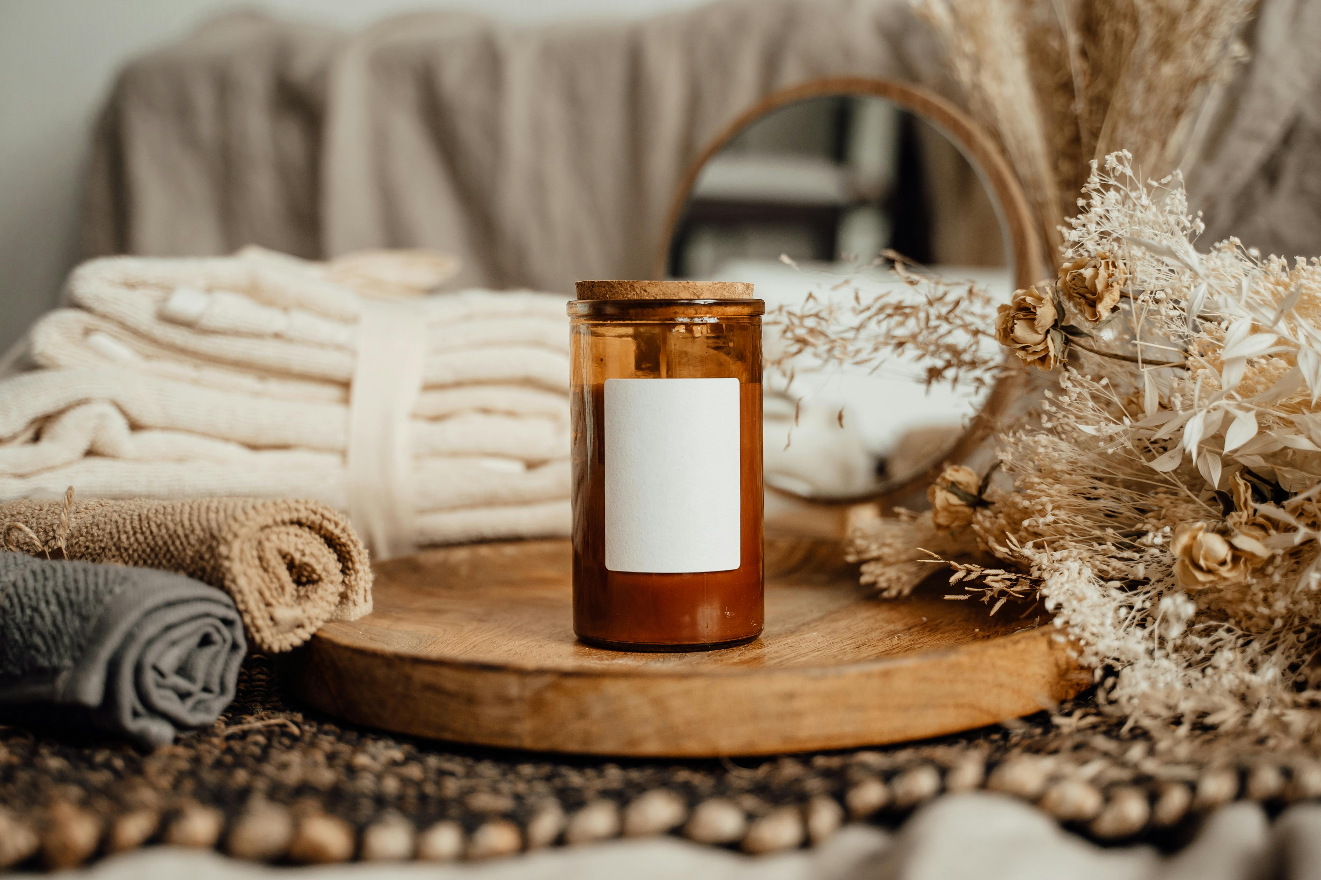Rustic setup featuring an aromatherapy candle with spa towels and dried flowers for a calming atmosphere.