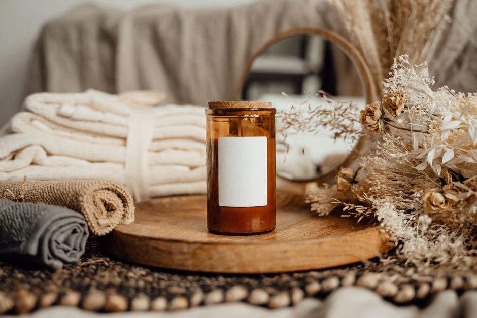 Rustic setup featuring an aromatherapy candle with spa towels and dried flowers for a calming atmosphere.