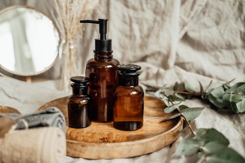 Free Stylish amber glass bottles on a rustic wooden tray, adding a cozy touch to any space. Stock Photo