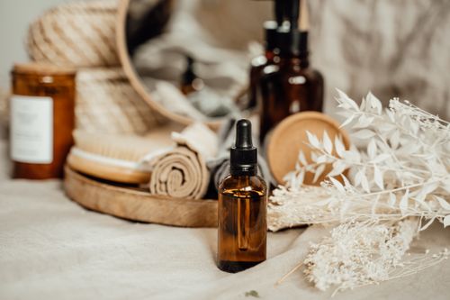 Free Close-up of aromatherapy essentials including amber bottles and dried flowers on a neutral setting. Stock Photo