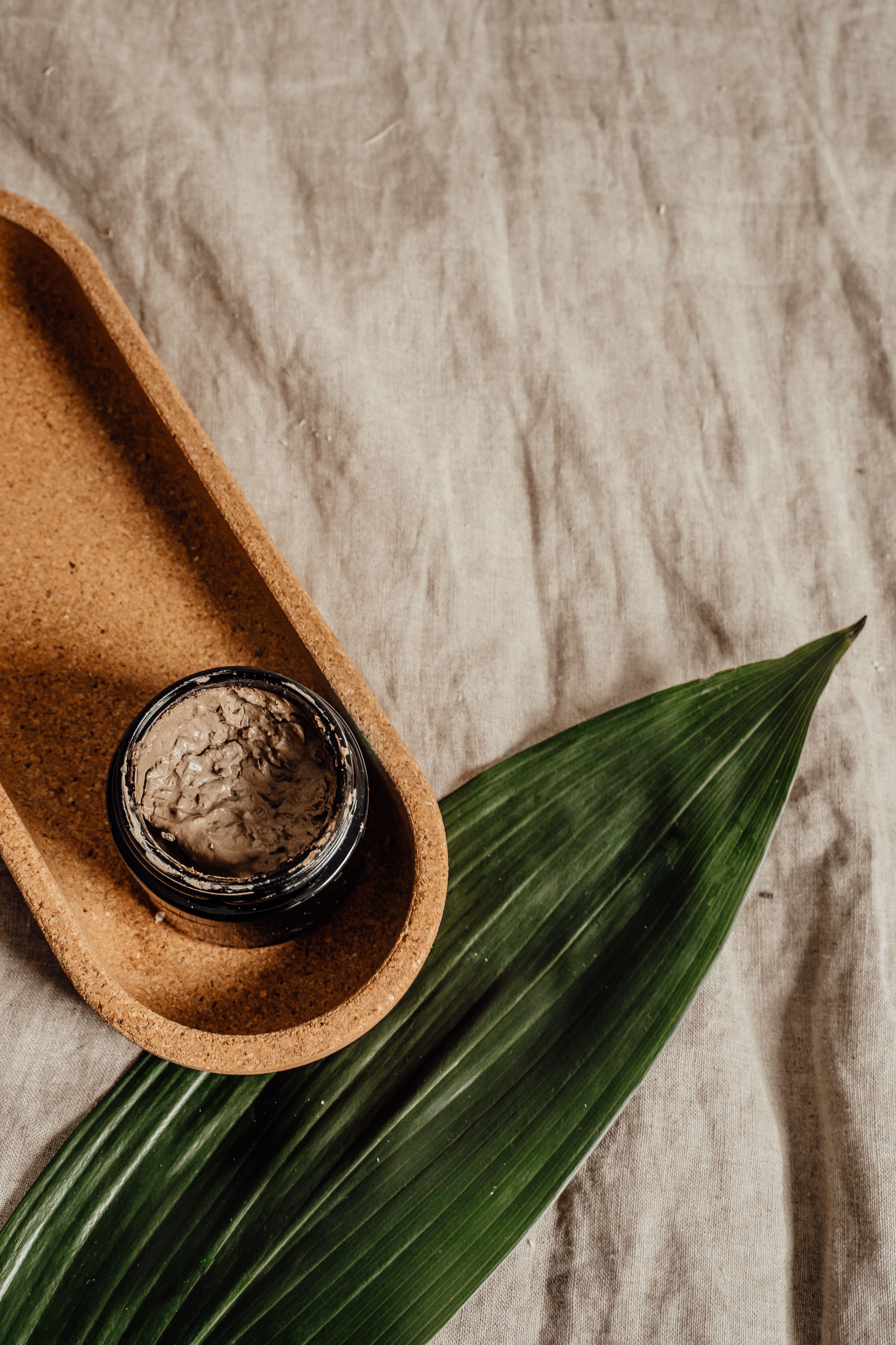 Minimalist flat lay of a skincare jar with natural textures, perfect for eco-friendly beauty brands.