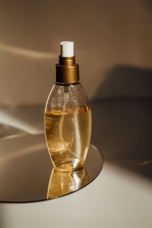 Free Close-up of a Glass Spray Bottle Standing on a Mirror  Stock Photo