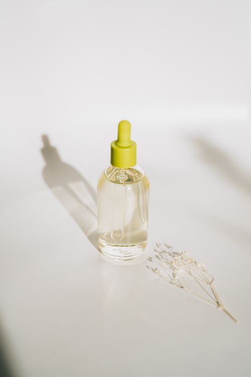 Free Elegant minimalist shot of an essential oil bottle with a dropper against a soft background. Stock Photo
