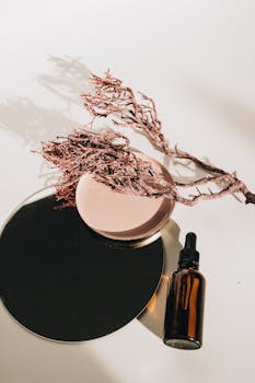 Aesthetic arrangement of a glass serum bottle with natural twigs and a plate, perfect for skincare branding.