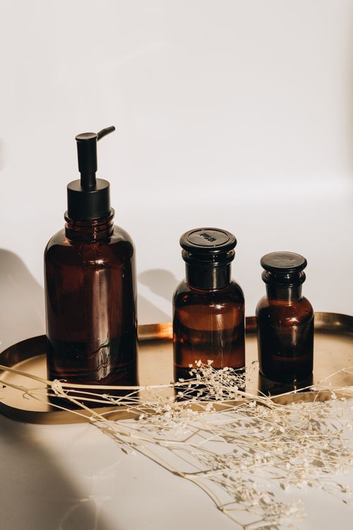 Free Chic skincare product arrangement with dried flowers and glass bottles on a tray. Stock Photo